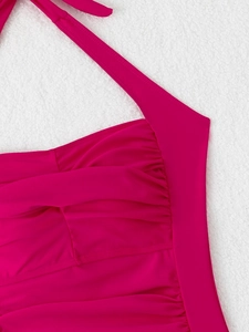 Detailed macro view of magenta halter swimwear with elegant pleated texture and ruching