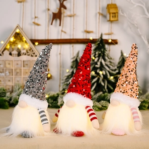 Three sequined Christmas gnomes with LED glowing beards in festive holiday decor