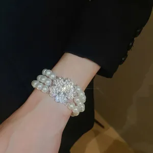 Elegant multi-layer pearl bracelet with sparkling floral diamond centerpiece for women