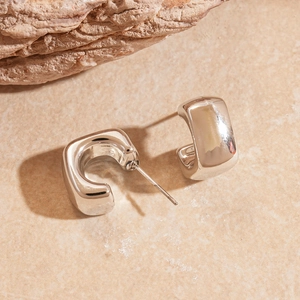 Detailed view of silver square C-shaped hoop earrings on a natural stone base