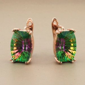 Detailed close-up of rose gold earrings with rainbow crystals and U-shaped buckles
