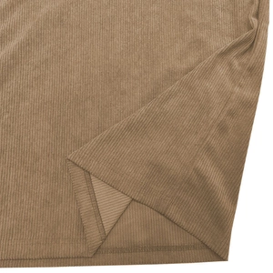 Detailed macro view of brown corduroy fabric texture and hem stitching on polo shirt