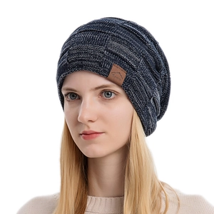 Winter chunky knit beanie hat in dark blue mixed yarn with a mountain leather patch