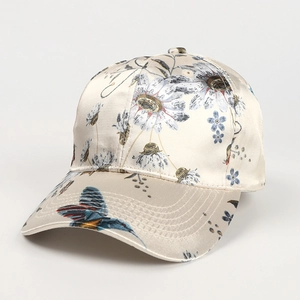 Detailed close-up of a satin baseball cap with floral prints and a colorful bird pattern