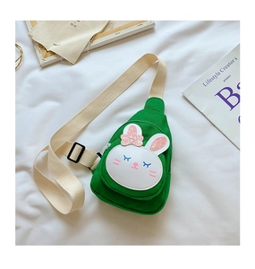 Close-up of green canvas bunny bag with pink sequin bow and beige adjustable strap