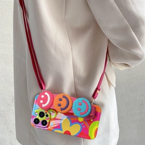Close-up of colorful floral iPhone case with woven strap and 3D smiley face charms