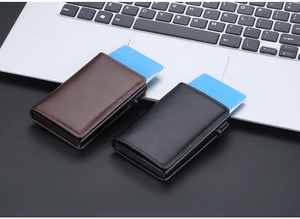Macro detail of brown and black leather RFID pop-up wallets on a professional desk