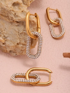 Détail des boucles d'oreilles en forme de U dorées avec incrustations de zircons cubiques