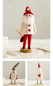 Three handmade wool felt Christmas ornaments with wooden bases in a warm holiday setting