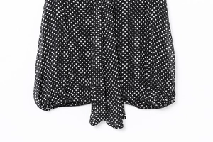 Close-up of black chiffon shirt with white polka dots showing hem and fabric texture