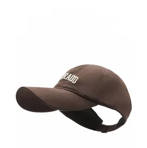 Detail of dark brown ponytail sun visor hat with white 3D embroidered lettering