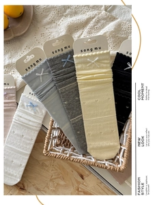 Detailed knit texture of colorful mid-calf socks with cute bow accents in a basket