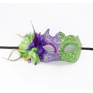 Detailed macro view of purple and green masquerade mask with feathers and gold glitter