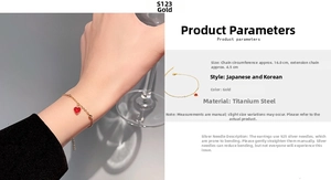 Detail view of a gold titanium steel chain bracelet featuring a delicate red heart pendant