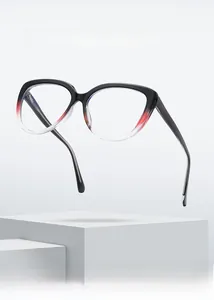 Detail view of cat-eye TR90 glasses frames with black to red gradient on a white pedestal