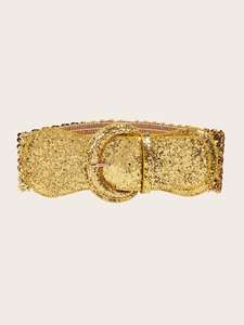 Macro detail of a wide gold elastic waist belt with glitter finish and round buckle