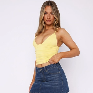 Close-up of yellow V-neck cropped tank top with ruched details and blue denim skirt