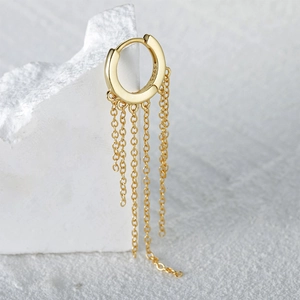 Macro shot of S925 sterling silver gold fringe chain earrings on white stone