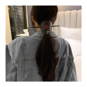 Pic à cheveux de style chinois moderne avec motif rose rouge sur cuir porté par femme
