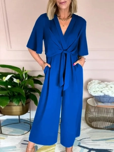 Detail view of royal blue V-neck short sleeve jumpsuit with waist tie and bow detail
