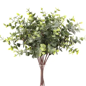Detailed view of artificial eucalyptus stems with berries in a clear glass bottle