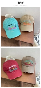 Detail of distressed brim and colorful embroidery on washed cotton baseball caps