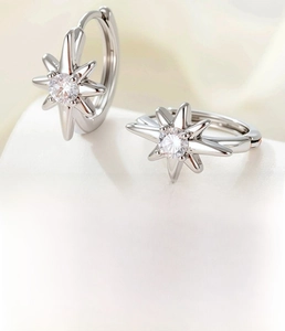 Macro view of star-shaped silver hoop earring with zircon inlay and product details