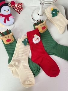 Detail of red and green Christmas socks with 3D reindeer, Santa and tree dolls