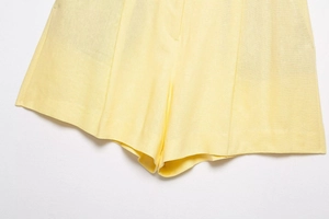 Detail of yellow cotton linen shorts showing textured weave and high-quality fabric finish