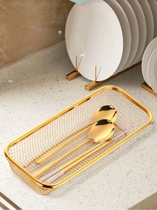 Close-up of golden stainless steel mesh cutlery basket with matching spoon and chopsticks