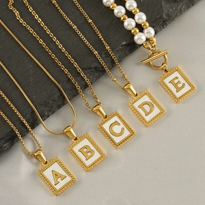 Goldene Edelstahl-Halsketten mit quadratischem Buchstaben-Anhänger auf Seidenstoff