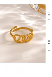 Close-up of golden matte interlocking chain ring on a white textured background