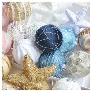 Close-up of velvet and sequin Christmas ornaments with pearls on white snowy background