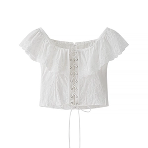 Top corto bianco a spalle scoperte con ricami a balze e allacciatura corsetto frontale