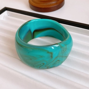 Detail of vintage gold-plated mother-of-pearl cuff with turquoise resin marbling texture