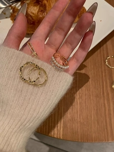 Close-up of golden pearl and diamond rings worn on hand for a layered elegant look