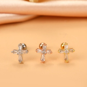 Macro shot of micro-paved zircon cross stud earrings in silver, gold, and rose gold