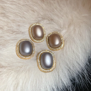 Detail of vintage oval stud earrings with gold plating, matte inlay and tiny crystals