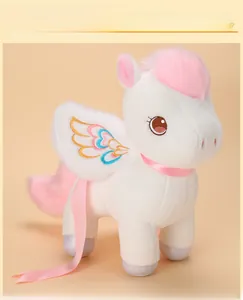 Detail of white plush unicorn toy with pink mane and colorful wing embroidery