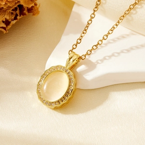 Detail of gold necklace featuring teardrop cat eye stone and pave diamond halo