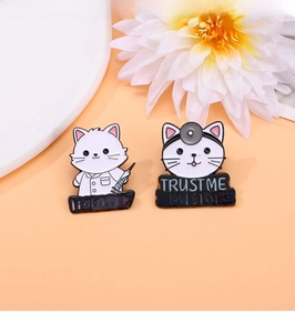 Detail of cartoon nurse and doctor cat enamel pins with medical text on pink background