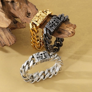 Heavy punk skull cuban chain bracelets in gold, silver, and black on wood