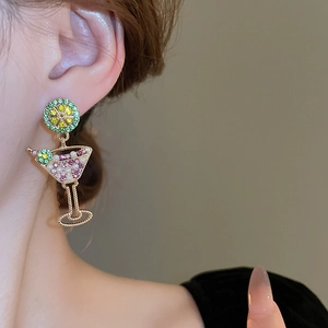 Creative cocktail glass earrings with faux pearls and lemon slices worn by a model