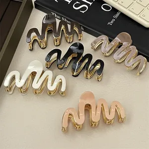 Detail of wavy acetate hair claws in five colors with durable gold metal springs