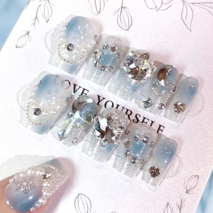 Detailed view of blue gradient press-on nails with luxury diamonds and pearl chains