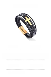 Dettaglio del bracciale in pelle intrecciata con croce in acciaio dorato e chiusura magnetica