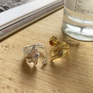 Irregular lava texture open rings in gold and silver finish on a wooden table
