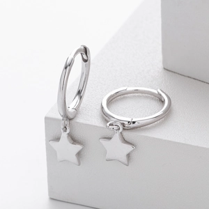 Detail of silver S925 sterling silver star drop earrings on white geometric background