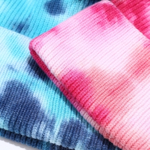 Close-up of tie-dye ribbed knit beanies showing detailed texture and color gradients