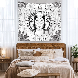 Detail of bohemian sun and moon tapestry with mystical galaxy patterns over a bed